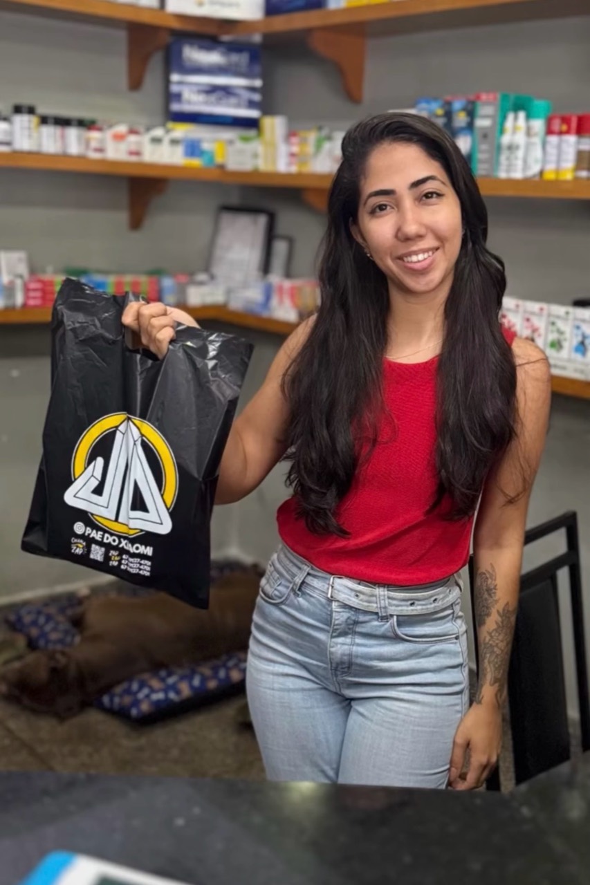 Cliente sorrindo com a sacola do Pai do Xiaomi